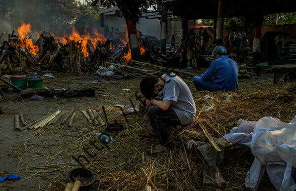 اعضای خانواده در یک کوره سوزی دسته جمعی در دهلی شرقی، هند در آوریل 2021.